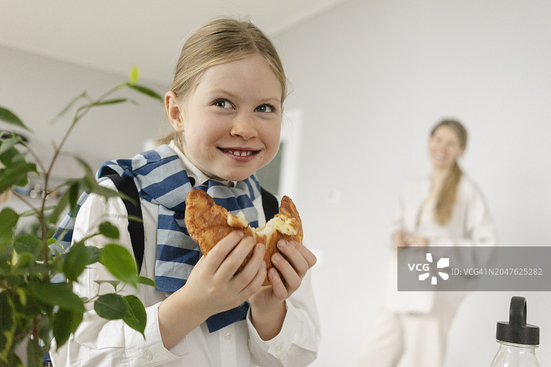 女孩在家吃羊角面包图片素材