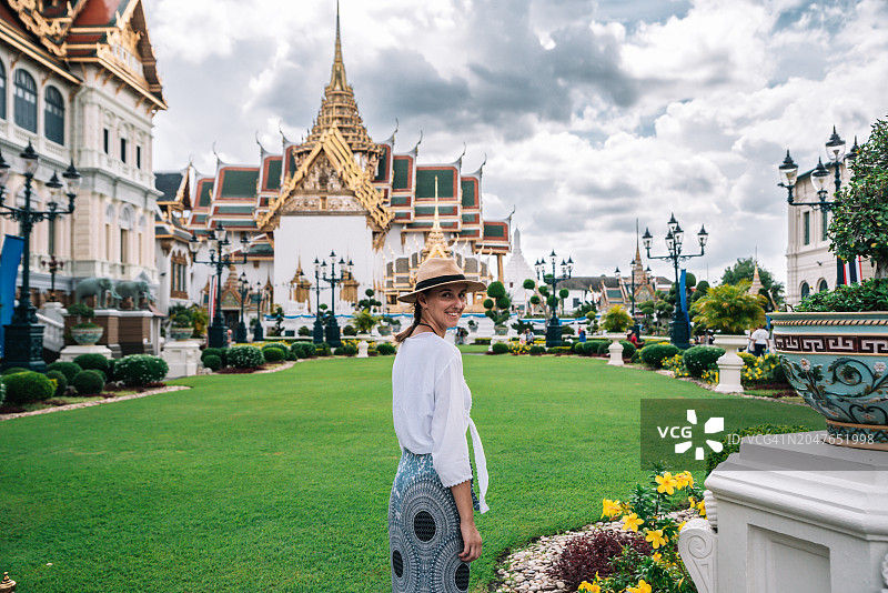 微笑的年轻女子在曼谷大皇宫花园里图片素材