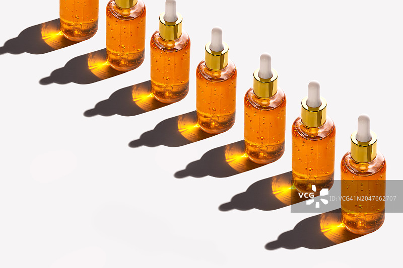 玻璃瓶滴管图案：柔和的桃色，白色背景，长阴影图片素材