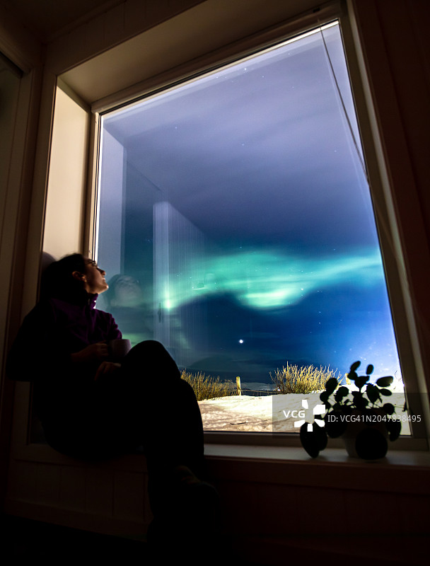 年轻女人正在观赏北极光图片素材