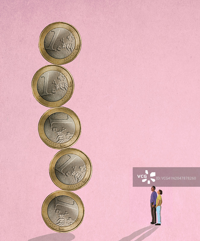 两个人看着不稳定的超大欧元硬币柱图片素材