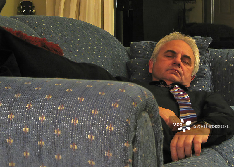 年长的男人在客厅的沙发上睡觉图片素材