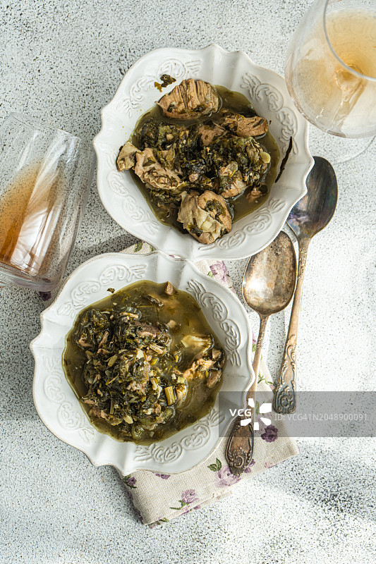 两碗传统格鲁吉亚羊肉和绿李子炖菜（Chakapuli）与两杯白葡萄酒俯视图图片素材