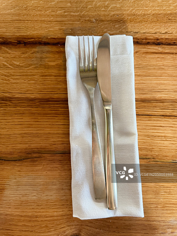 木桌上的刀叉与餐巾俯视图图片素材