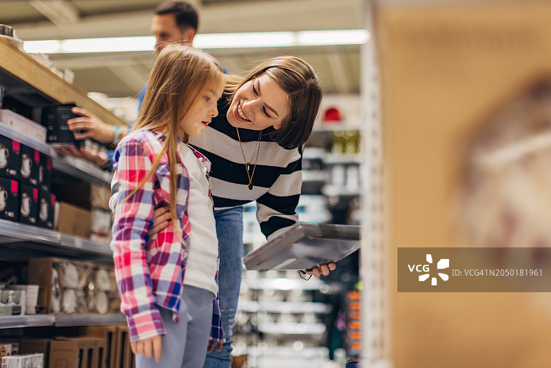 面带微笑的母亲和女儿正在为新公寓选择餐具图片素材