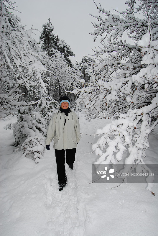 在霍恩德洛米格尔伦堡附近雪林中行走的女人图片素材