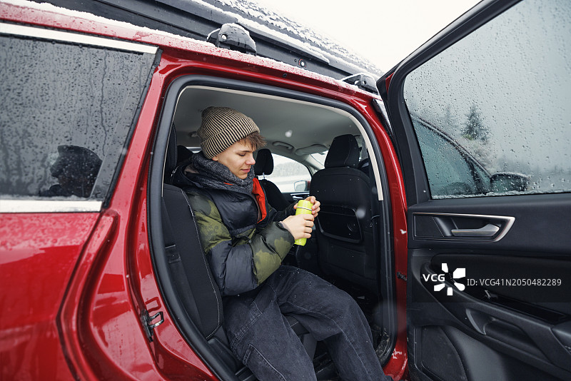在休息站喝热茶的少年男人坐在车里图片素材