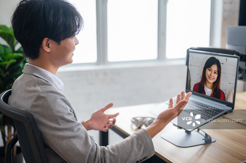虚拟连接：年轻的亚洲商人主持视频会议图片素材