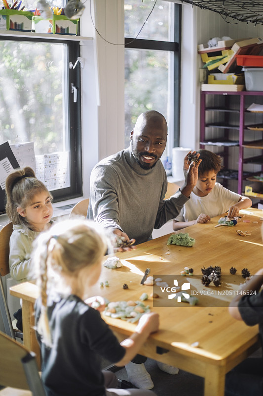 男老师在学前班的美术课上和孩子们玩耍图片素材