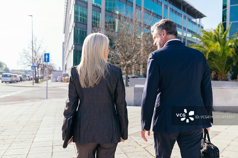 商务人士在城市街道上行走的背影图片素材