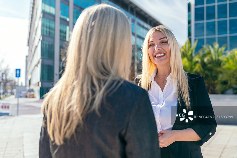 两位女商人在户外进行友好交谈图片素材
