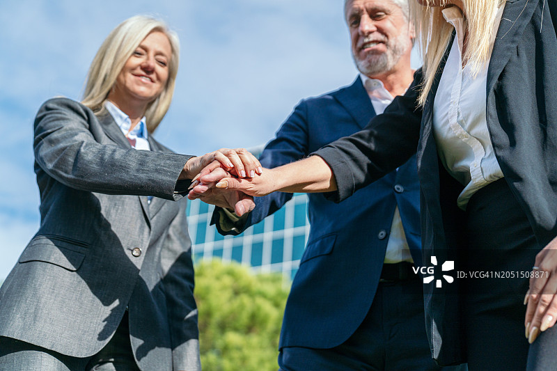 团结一致的商务团队在办公室外携手合作图片素材