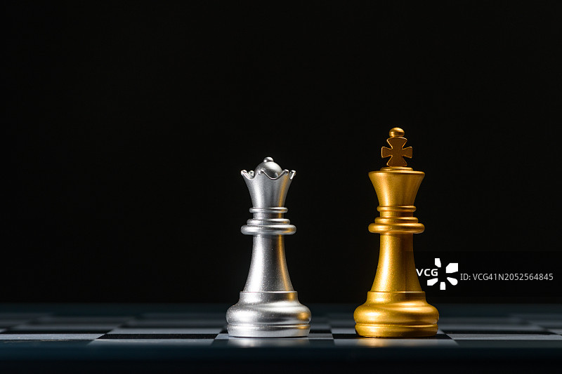黑色背景下的欺骗国王和王后棋图片素材