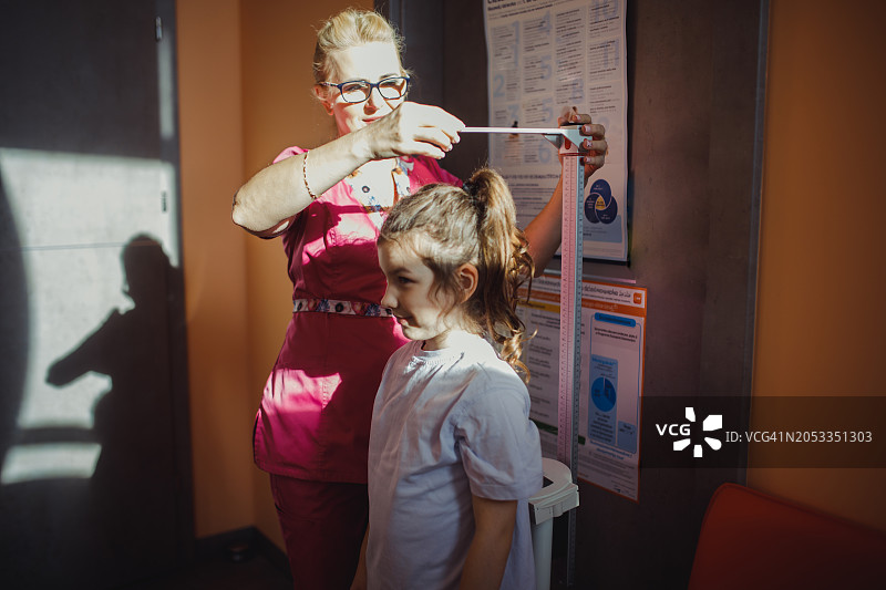 戴眼镜的女医生为小女孩进行体检图片素材