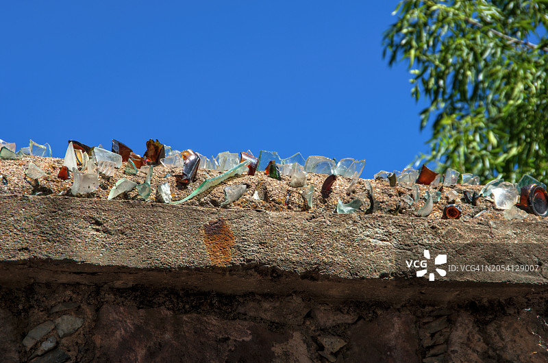 镶嵌在混凝土石墙上的碎玻璃图片素材
