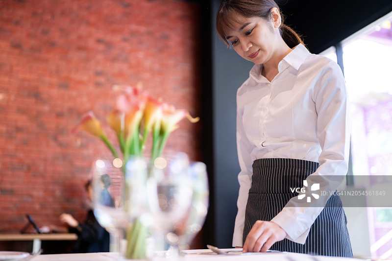 正在摆放餐桌的女服务员图片素材