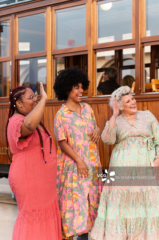 向抵达城市的其他朋友挥手的女性图片素材