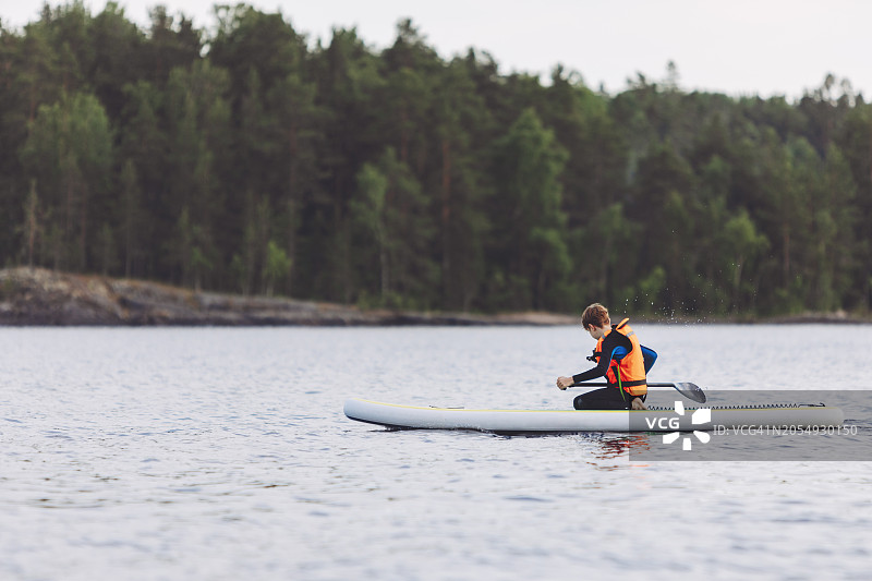 在湖上划桨板的男孩图片素材
