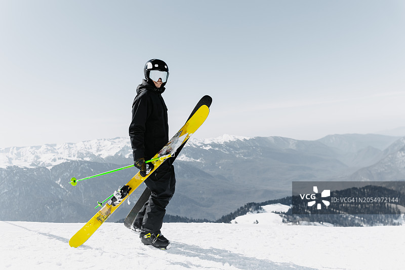 滑雪者身穿黑色连体衣，在山上滑雪图片素材