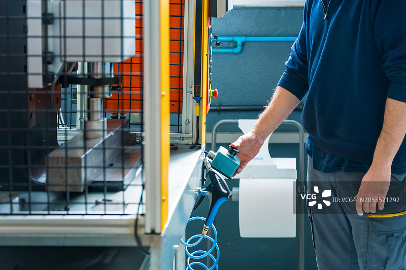 男人在包装厂操作铆钉机图片素材