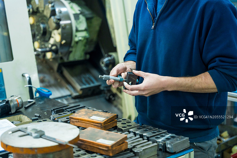工厂内，接线员检查零件尺寸图片素材