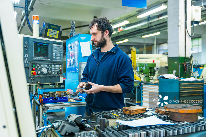 工人在数控工厂测量和检查零件图片素材