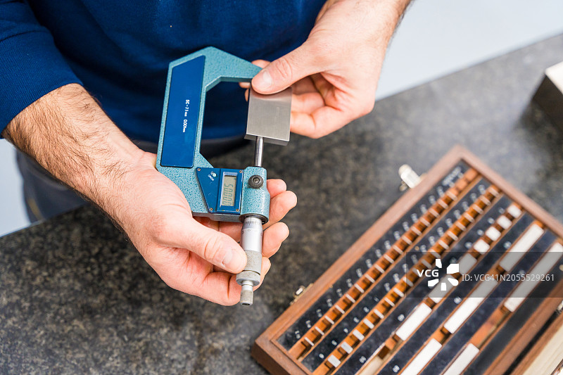 工程师使用卡尺进行零件控制检查图片素材