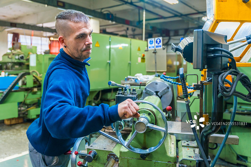 在工厂使用数控铣床的男人图片素材