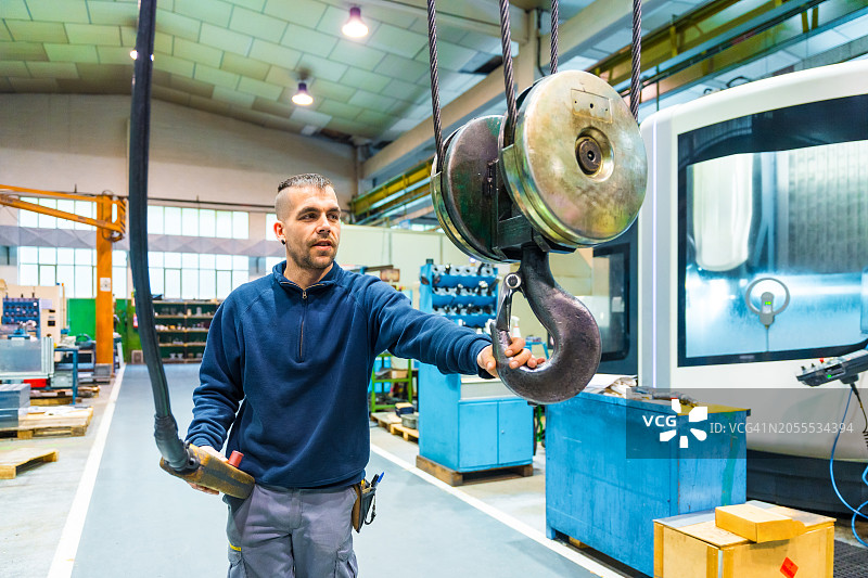 工人使用遥控器操作起重机图片素材