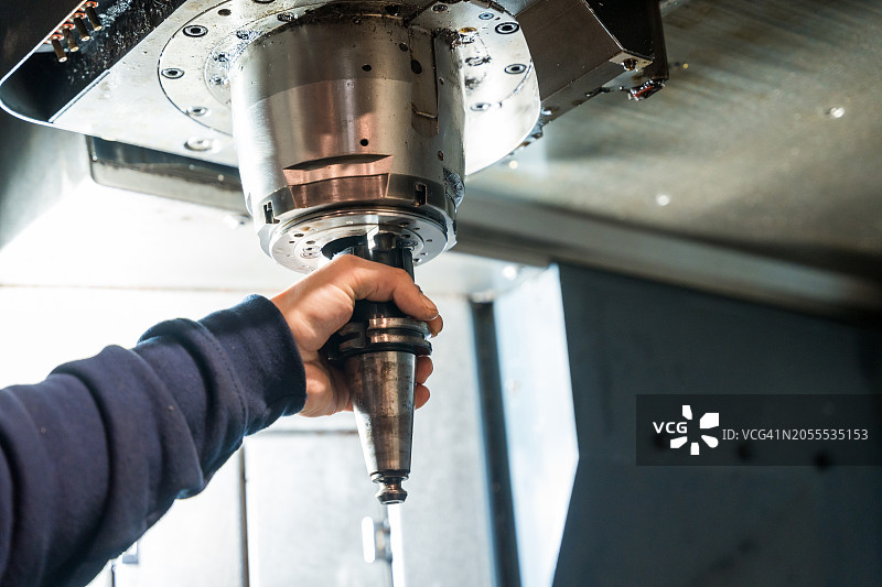 工人在数控工厂调整铣床图片素材