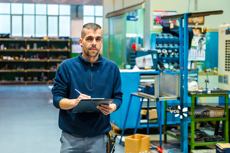 工人在数控工厂进行盘点时书写图片素材