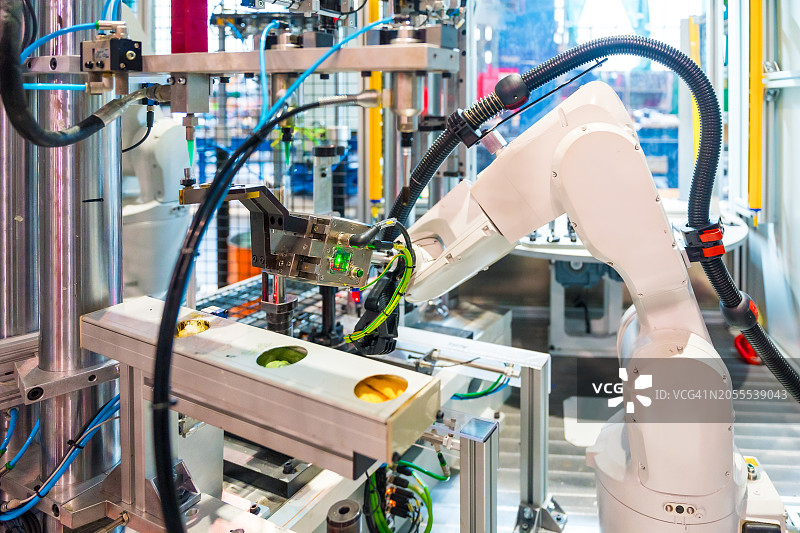 工厂中在数控机床上工作的机械臂图片素材