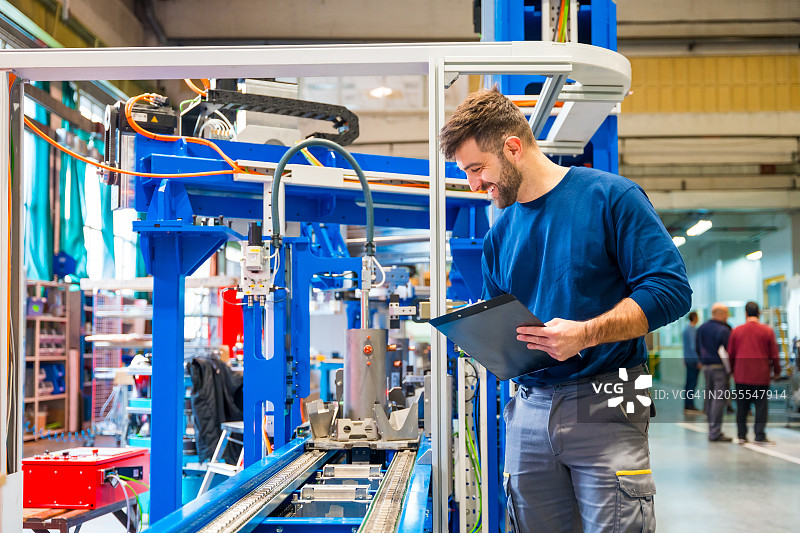 工程师在车间检查正在组装的机床图片素材