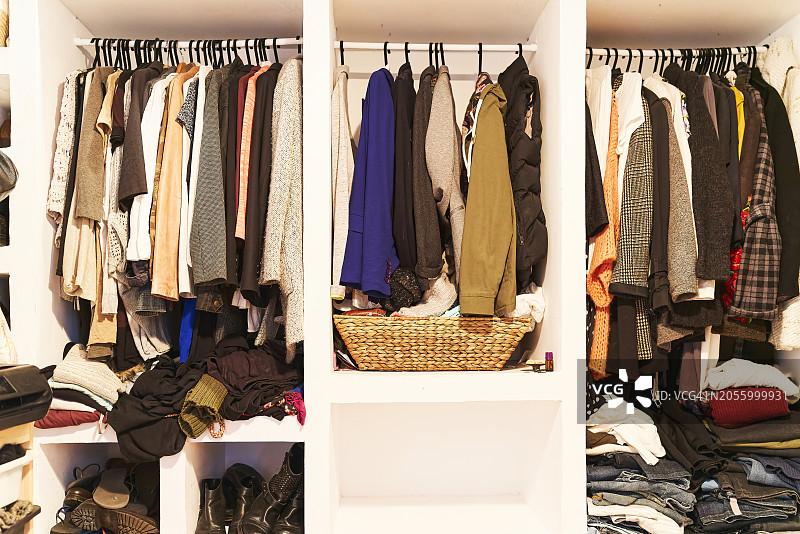 衣柜里挂着的一组衣服的正面图，前景中没有人图片素材