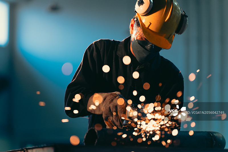 技术人员在工厂用切割机切割铁管图片素材