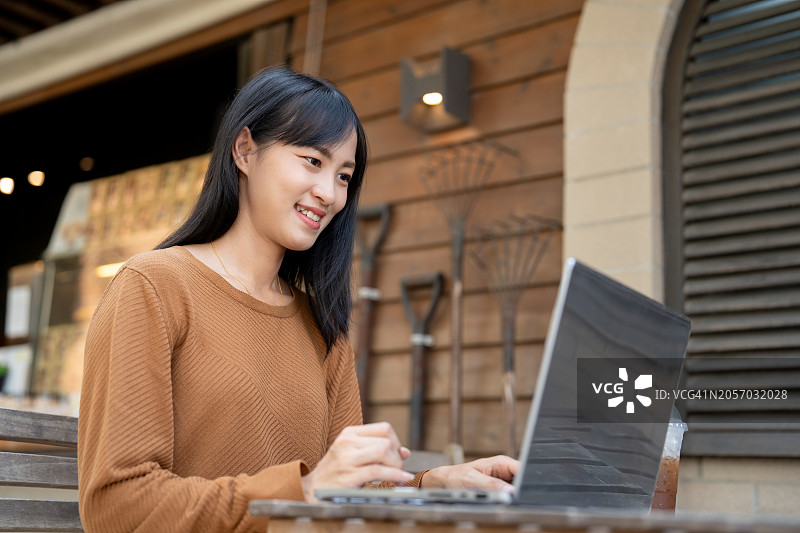 随时随地远程工作：亚洲女性在办公室外通过互联网主持会议图片素材
