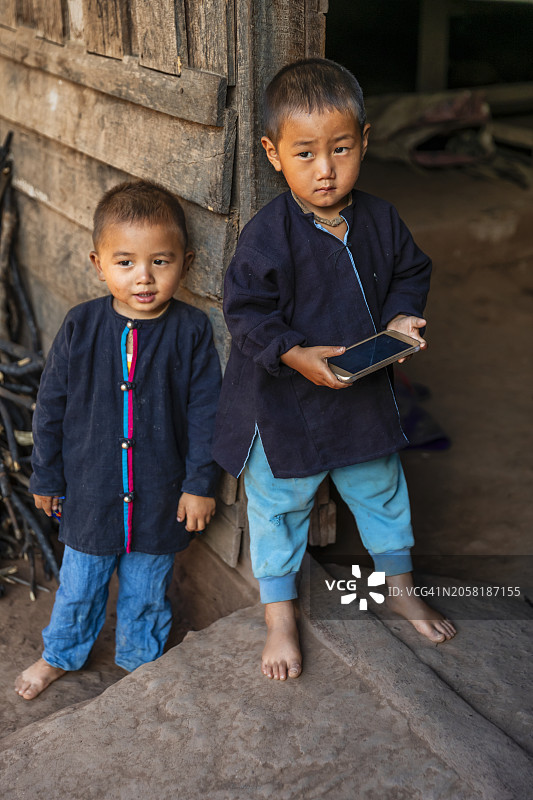 老挝北部村庄里玩智能手机的男孩图片素材