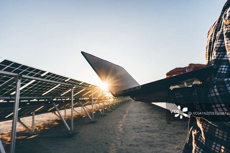 男工程师在太阳能发电站使用笔记本电脑图片素材