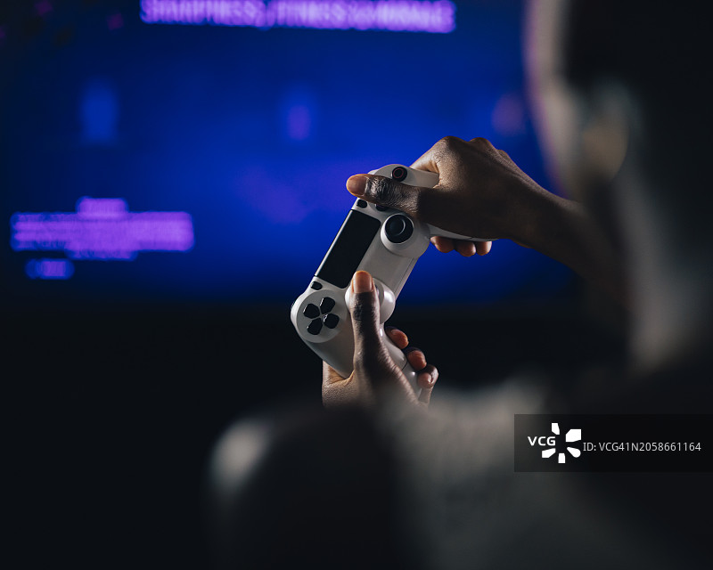 男子在家玩视频游戏的肩部视角特写，美国德克萨斯州科珀斯克里斯蒂图片素材