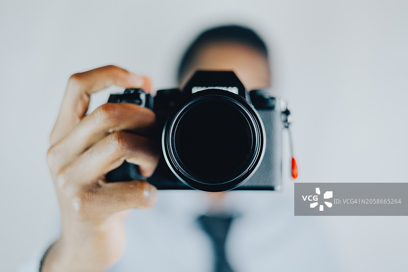 女子在美国德克萨斯州科珀斯克里斯蒂用相机对着白色背景拍照的特写图片素材