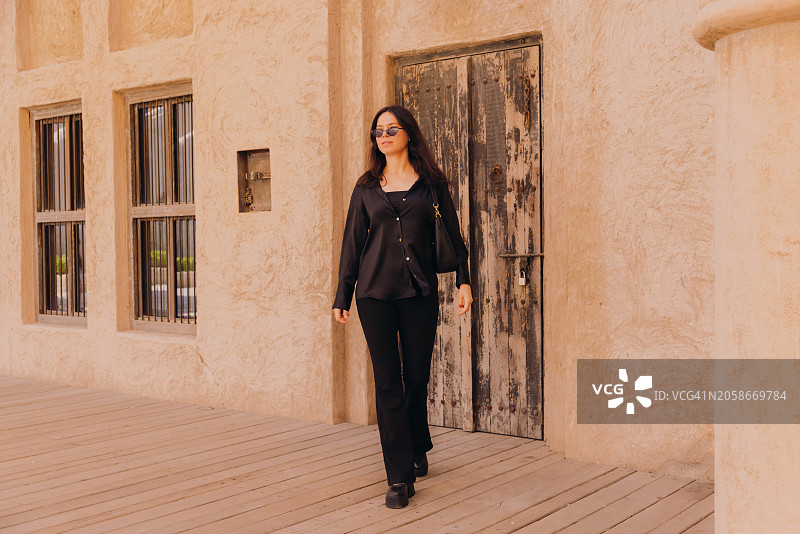 漫步在迪拜老城区街道上的旅行女人图片素材