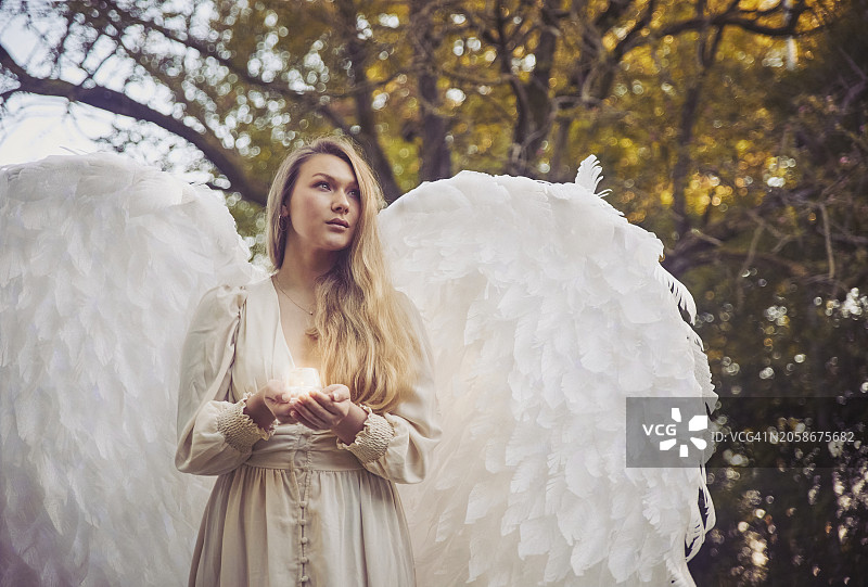 夜晚森林中拿着蜡烛的女孩天使图片素材