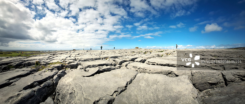 人们走在岩石景观上，以天空为背景的美景图片素材