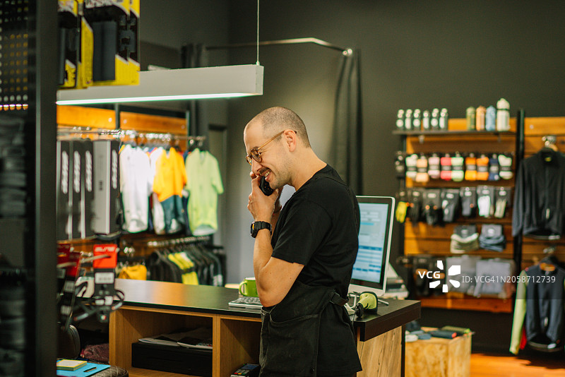 男人在西班牙莱里达商店咖啡机旁打电话图片素材