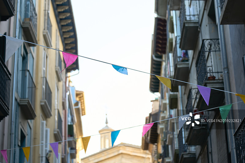 小巷装饰着一排排彩色banner，是城市庆典的典型场景图片素材