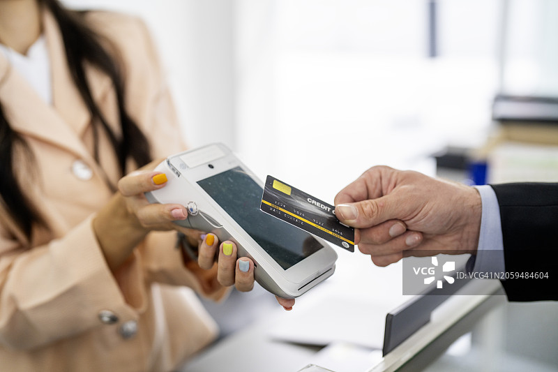 咖啡馆里女人用信用卡支付账单的手部特写图片素材