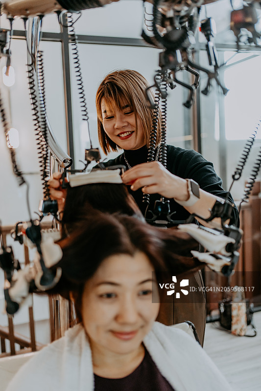 中国发型师高兴地为顾客做头发图片素材