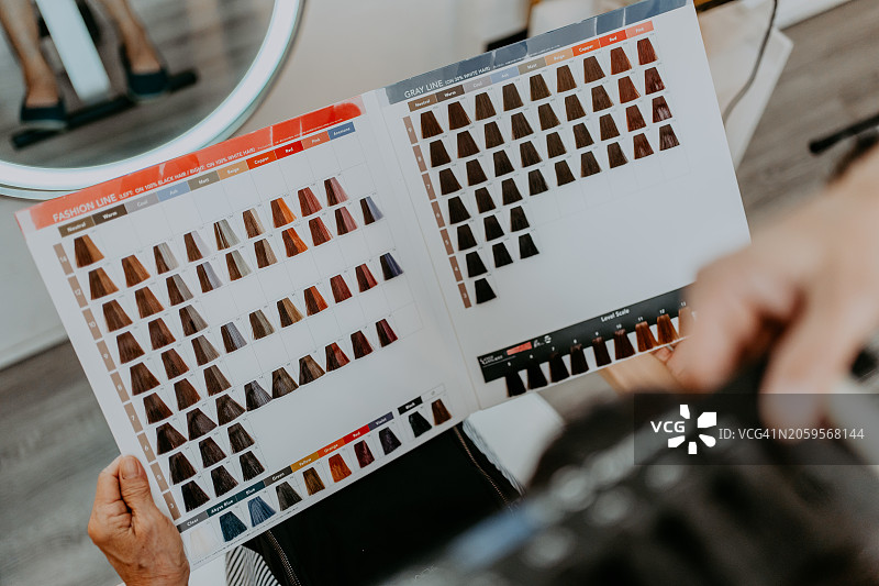 在沙龙里，老式造型师为顾客染发图片素材