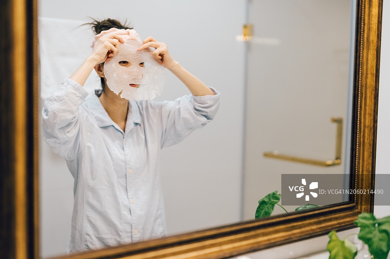 亚洲年轻女人在家戴着面膜图片素材