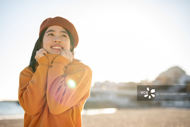 在西班牙海滩日落时放松呼吸新鲜空气的日本女子图片素材